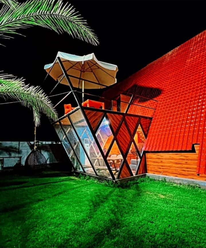 A-frame cabin illuminated at night with rooftop terrace