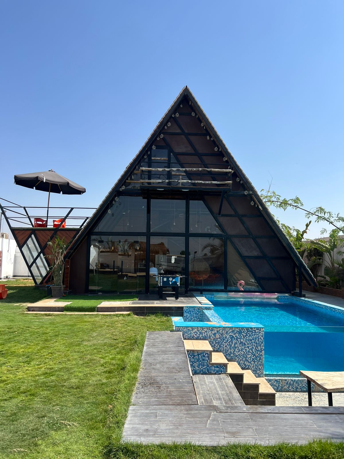 European Hut cabin exterior with pool and lush landscape