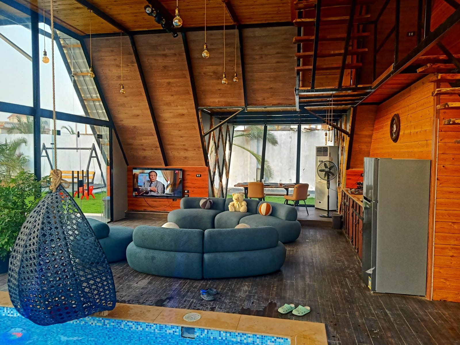 Spacious A-frame living area with curved sofa and indoor pool