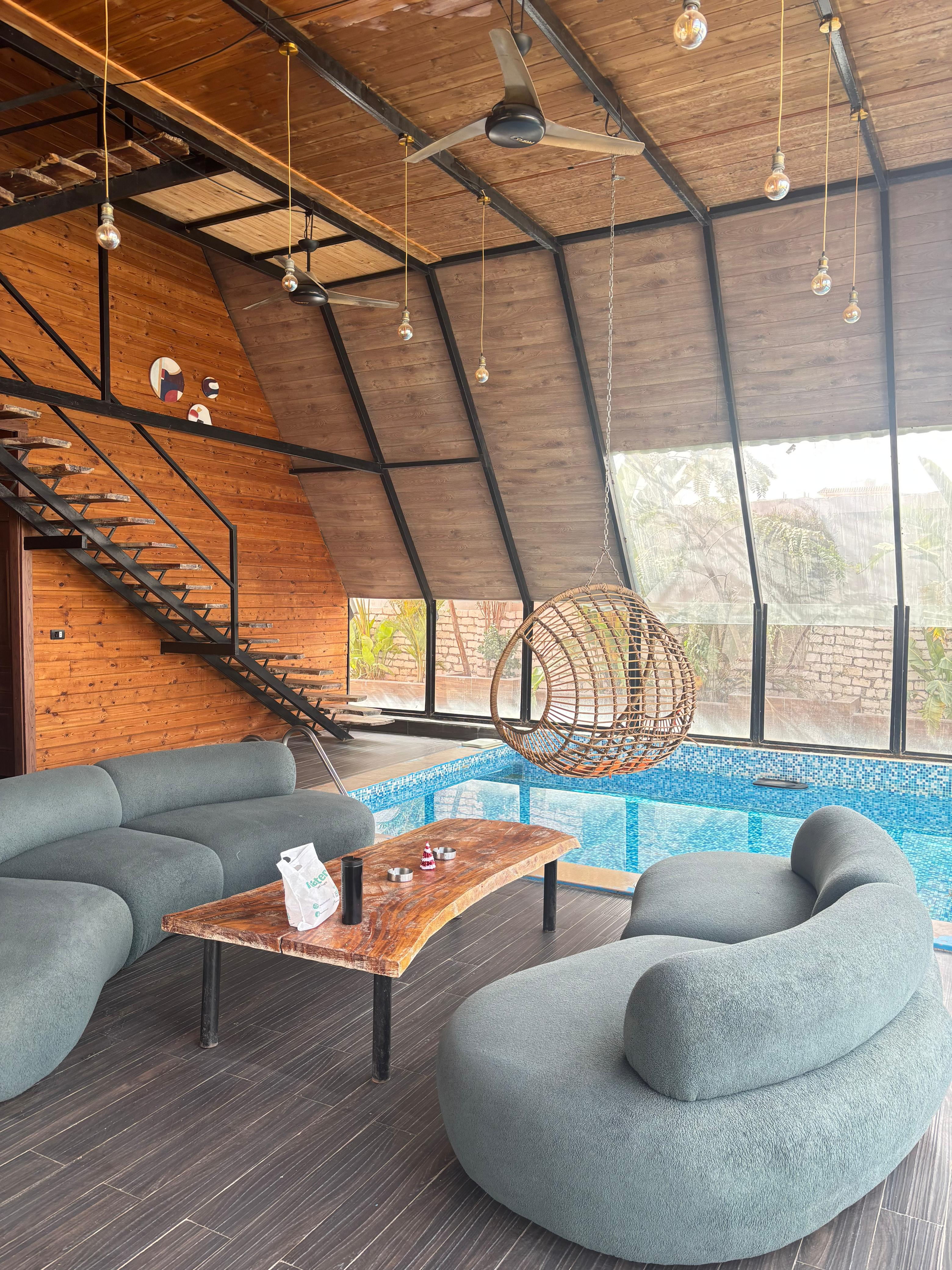 Indoor lounge with swing chair, sofas, and pool